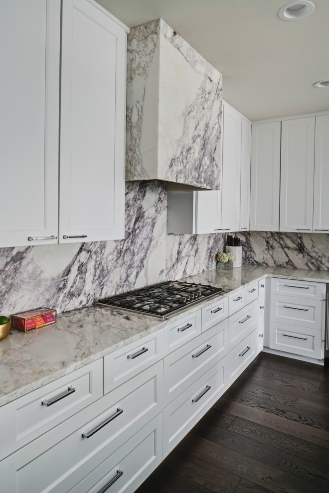 Open concept kitchen - large transitional l-shaped dark wood floor and brown floor open concept kitchen idea in Chicago with an undermount sink, shaker cabinets, white cabinets, marble countertops, beige backsplash, marble backsplash, stainless steel appliances, an island and beige countertops