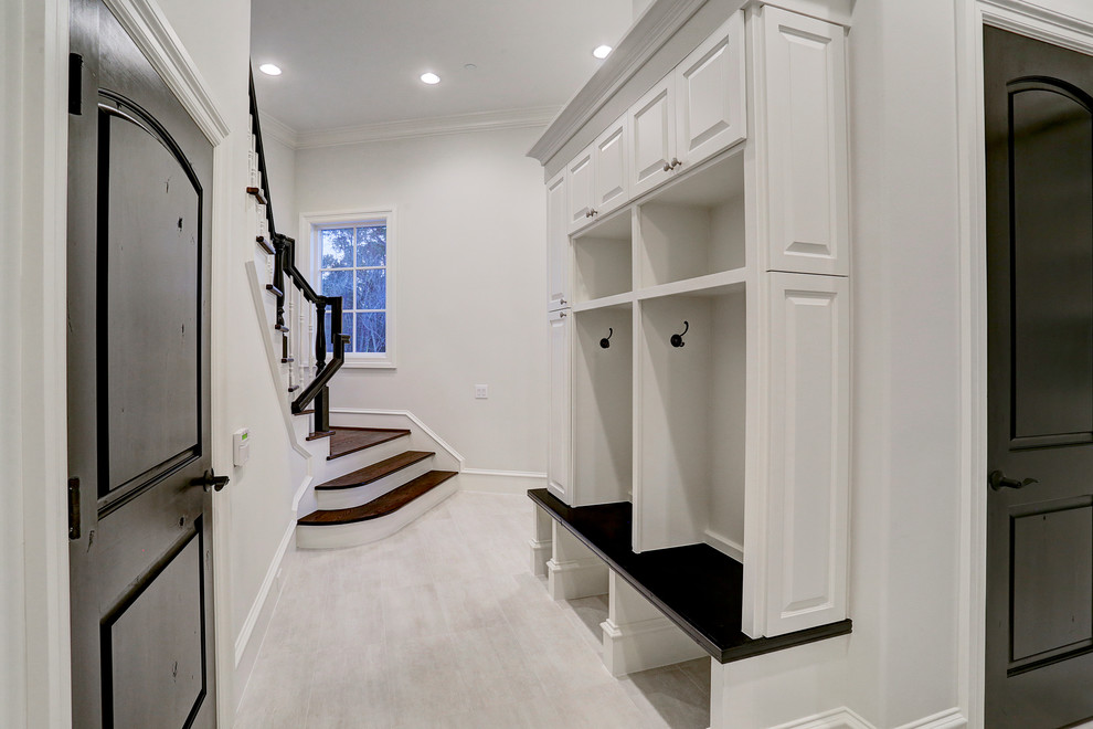 Inspiration for a traditional hallway in Houston with white walls, ceramic floors and beige floor.