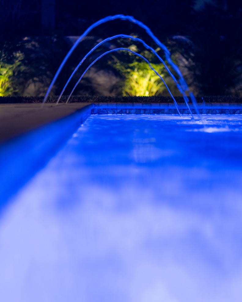 Pool - mid-sized modern backyard stone pool idea in Tampa