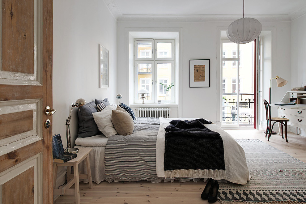 Mid-sized scandinavian master bedroom in Gothenburg with white walls, light hardwood floors and no fireplace.