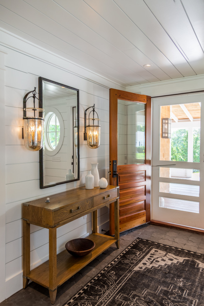 Inspiration for a mid-sized beach style mudroom in Boston with white walls, ceramic floors, a single front door, a medium wood front door, brown floor, timber and planked wall panelling.