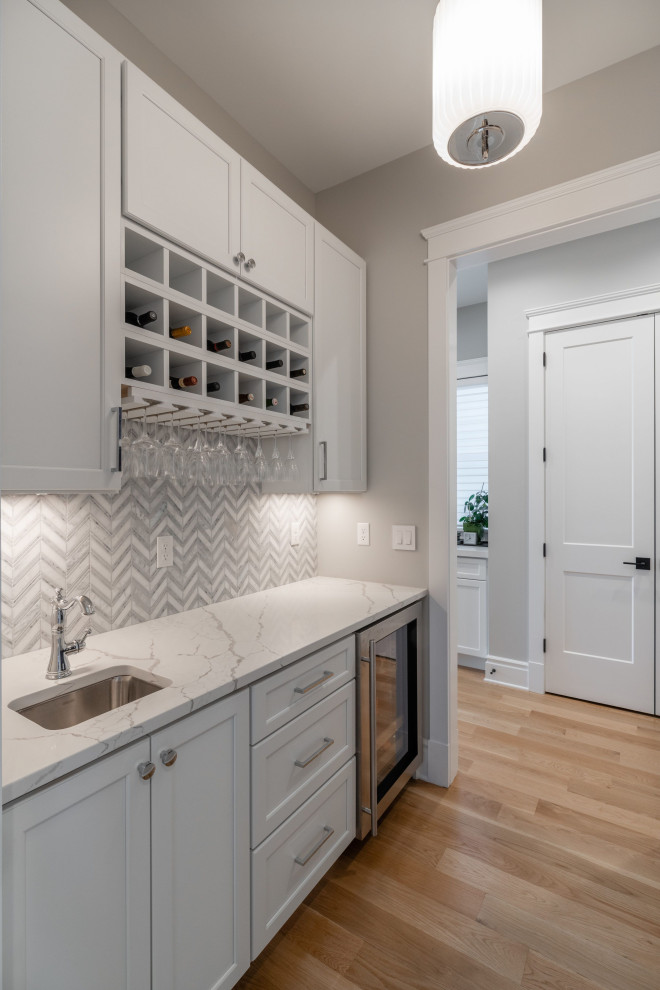 Design ideas for a mid-sized transitional single-wall wet bar in DC Metro with an undermount sink, shaker cabinets, grey cabinets, grey splashback, beige floor and grey benchtop.