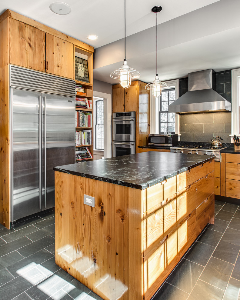 Photo of a country kitchen in Dallas with flat-panel cabinets, medium wood cabinets, grey splashback, stainless steel appliances, with island and slate splashback.
