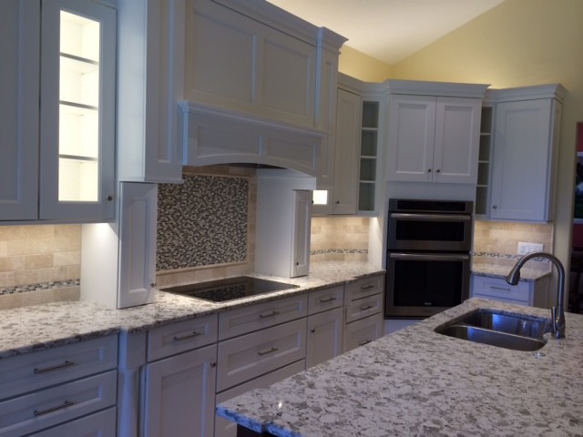Inspiration for a mid-sized transitional travertine floor open concept kitchen remodel with an undermount sink, recessed-panel cabinets, white cabinets, quartz countertops, stone tile backsplash, stainless steel appliances and an island