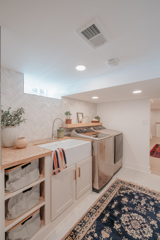 Design ideas for a small contemporary galley separated utility room in Detroit with a belfast sink, shaker cabinets, beige cabinets, wood worktops, a side by side washer and dryer and brown worktops.