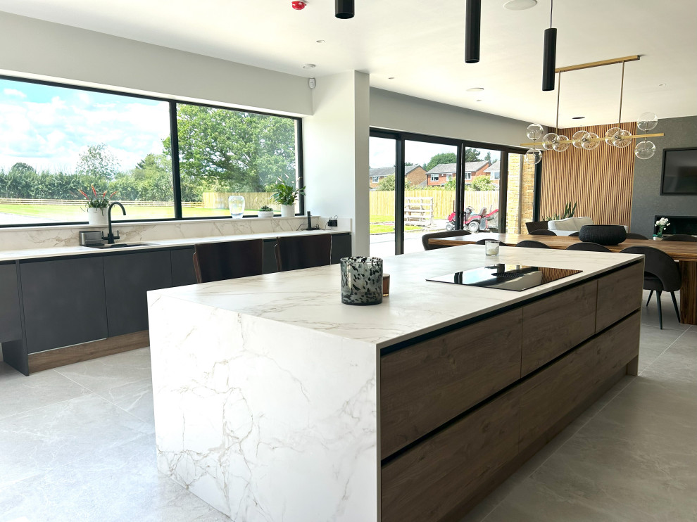 This is an example of a large contemporary kitchen in Other with flat-panel cabinets, black appliances and with island.