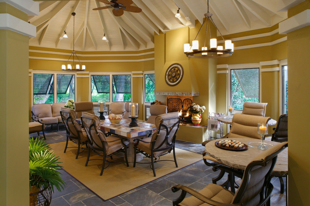 Photo of a tropical sunroom in Jacksonville with slate floors, a standard fireplace and a brick fireplace surround.