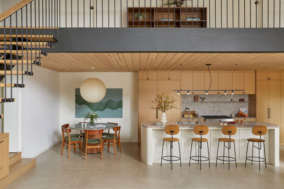 Photo of a mid-sized midcentury single-wall open plan kitchen in San Francisco with an undermount sink, flat-panel cabinets, light wood cabinets, terrazzo benchtops, grey splashback, cement tile splashback, panelled appliances, porcelain floors, with island, beige floor, grey benchtop and wood.