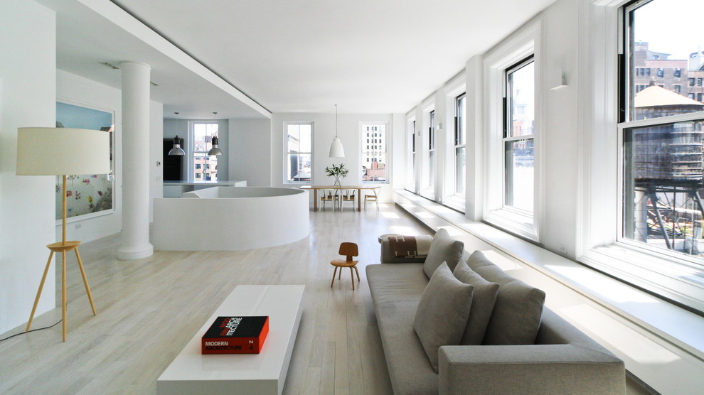 Large scandinavian formal open concept living room in New York with white walls, light hardwood floors and no fireplace.