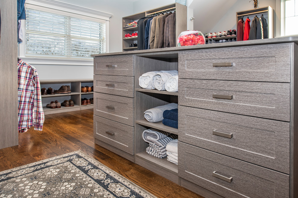 Design ideas for a large transitional gender-neutral walk-in wardrobe in Chicago with shaker cabinets, grey cabinets, medium hardwood floors and brown floor.