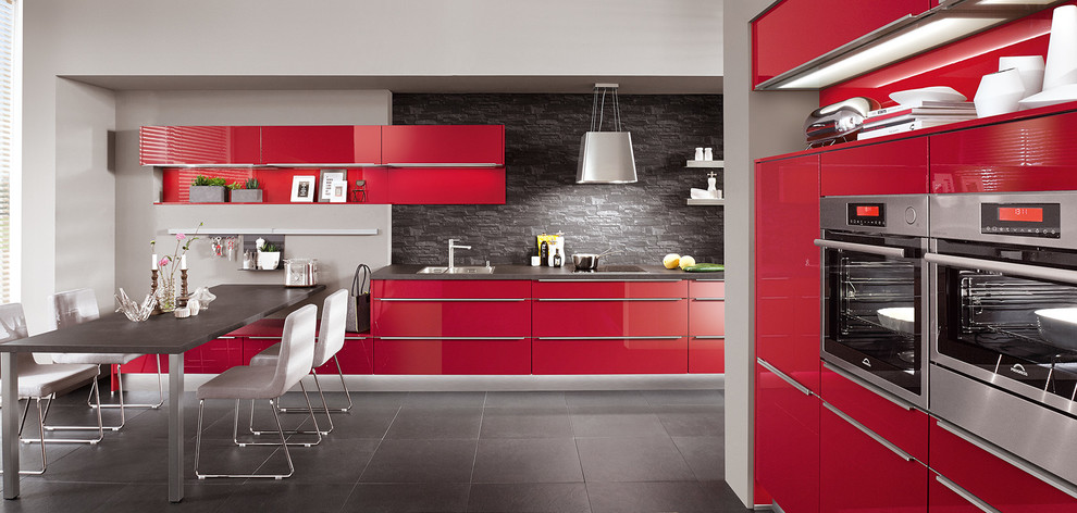 Mid-sized modern single-wall separate kitchen in Madrid with an integrated sink, shaker cabinets, red cabinets, stainless steel appliances, marble benchtops, red splashback, glass sheet splashback, ceramic floors, grey floor and grey benchtop.