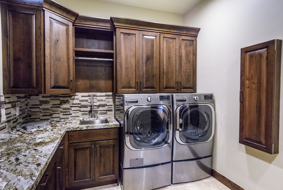Design ideas for a mid-sized u-shaped dedicated laundry room in Salt Lake City with an undermount sink, raised-panel cabinets, dark wood cabinets, granite benchtops, multi-coloured splashback, ceramic splashback, ceramic floors, white walls and a side-by-side washer and dryer.