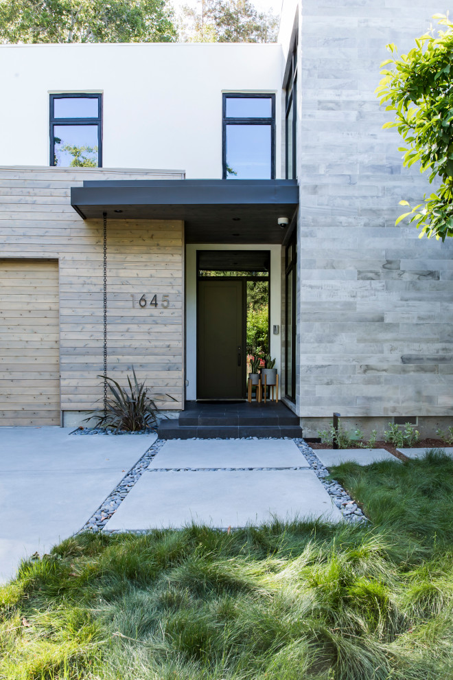 Esempio di un grande portico minimal davanti casa con pavimentazioni in cemento e un tetto a sbalzo