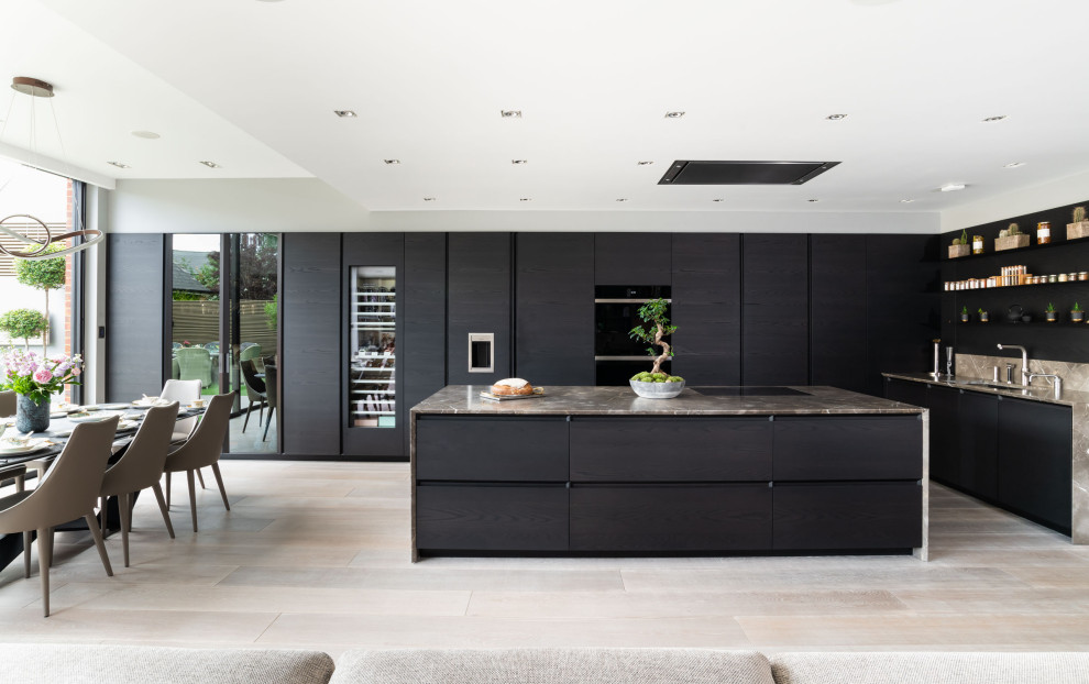 Design ideas for an expansive contemporary open plan kitchen in London with flat-panel cabinets, dark wood cabinets, marble benchtops, brown splashback, marble splashback, light hardwood floors, with island, beige floor, brown benchtop, an undermount sink and panelled appliances.