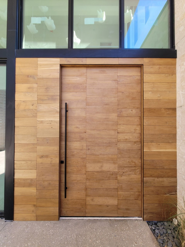 Imagen de puerta principal grande con suelo de terrazo, puerta pivotante y puerta de madera clara