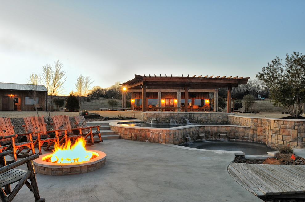 Design ideas for an expansive courtyard patio in Houston with a fire feature, concrete slab and a pergola.