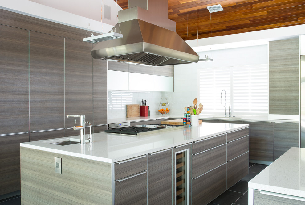 Inspiration for a large transitional l-shaped eat-in kitchen in Houston with an undermount sink, flat-panel cabinets, medium wood cabinets, yellow splashback, glass tile splashback, stainless steel appliances, porcelain floors, multiple islands and quartz benchtops.