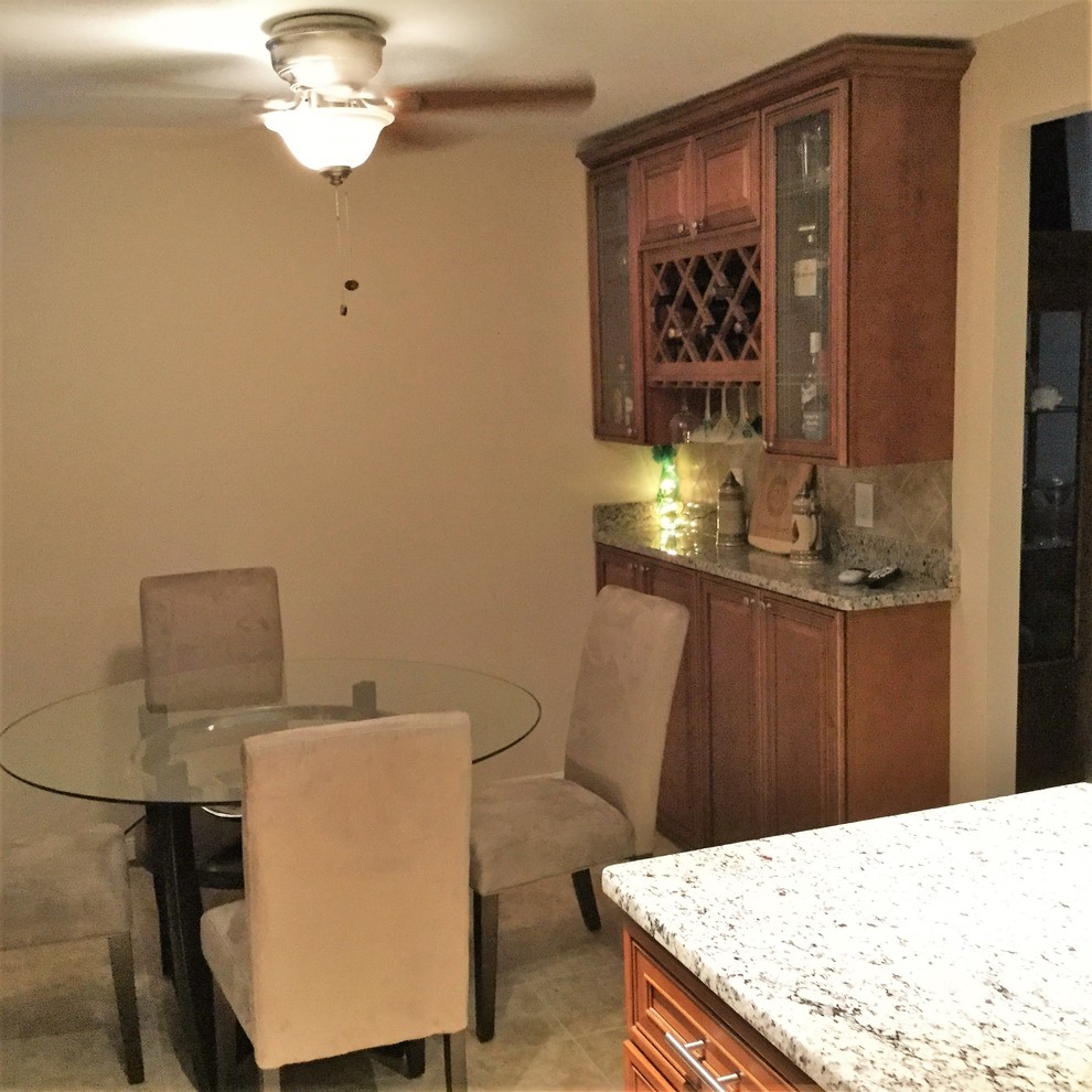 Example of a large transitional l-shaped porcelain tile eat-in kitchen design in DC Metro with an undermount sink, raised-panel cabinets, medium tone wood cabinets, granite countertops, beige backsplash, porcelain backsplash, stainless steel appliances and an island
