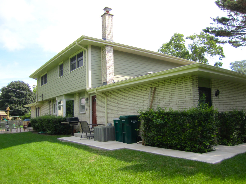 Mid-sized country two-storey green exterior in Chicago with mixed siding.
