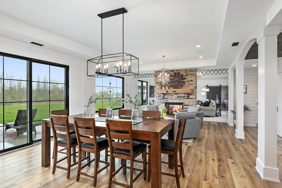 Inspiration for a country kitchen/dining combo in Grand Rapids with white walls, vinyl floors and brown floor.