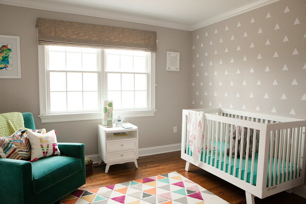 Modern nursery in New York with beige walls, dark hardwood floors and brown floor for girls.