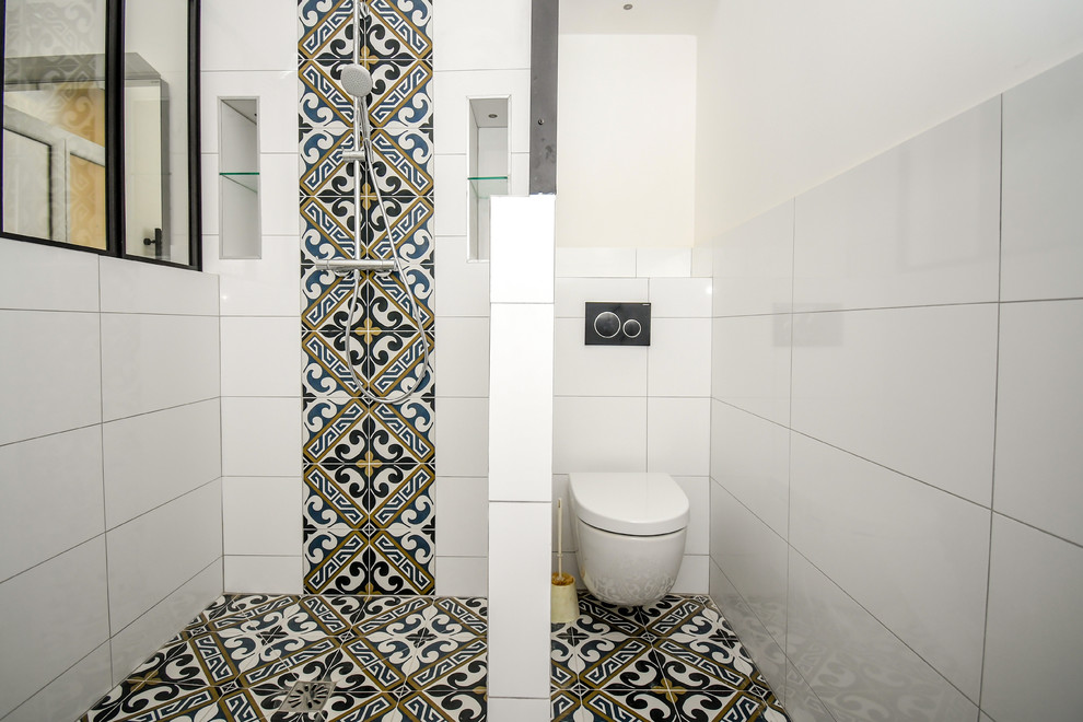 Photo of a large industrial 3/4 bathroom in Other with an open shower, a wall-mount toilet, white tile, terra-cotta tile, white walls, cement tiles, a console sink, solid surface benchtops, black floor and white benchtops.