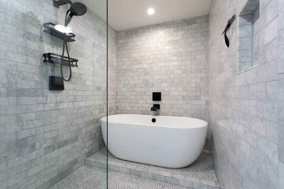 Photo of a medium sized contemporary ensuite bathroom in Los Angeles with flat-panel cabinets, brown cabinets, a freestanding bath, a shower/bath combination, a one-piece toilet, grey tiles, marble tiles, white walls, marble flooring, an integrated sink, granite worktops, grey floors, a hinged door, black worktops, an enclosed toilet, double sinks and a floating vanity unit.