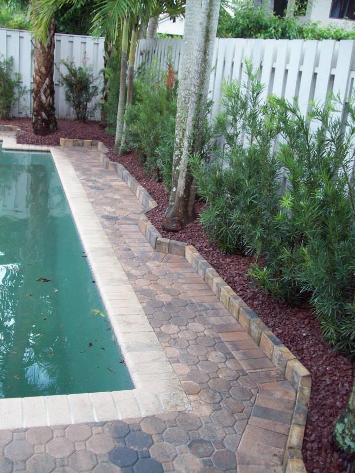 Photo of a mid-sized mediterranean backyard rectangular pool in Miami with brick pavers.
