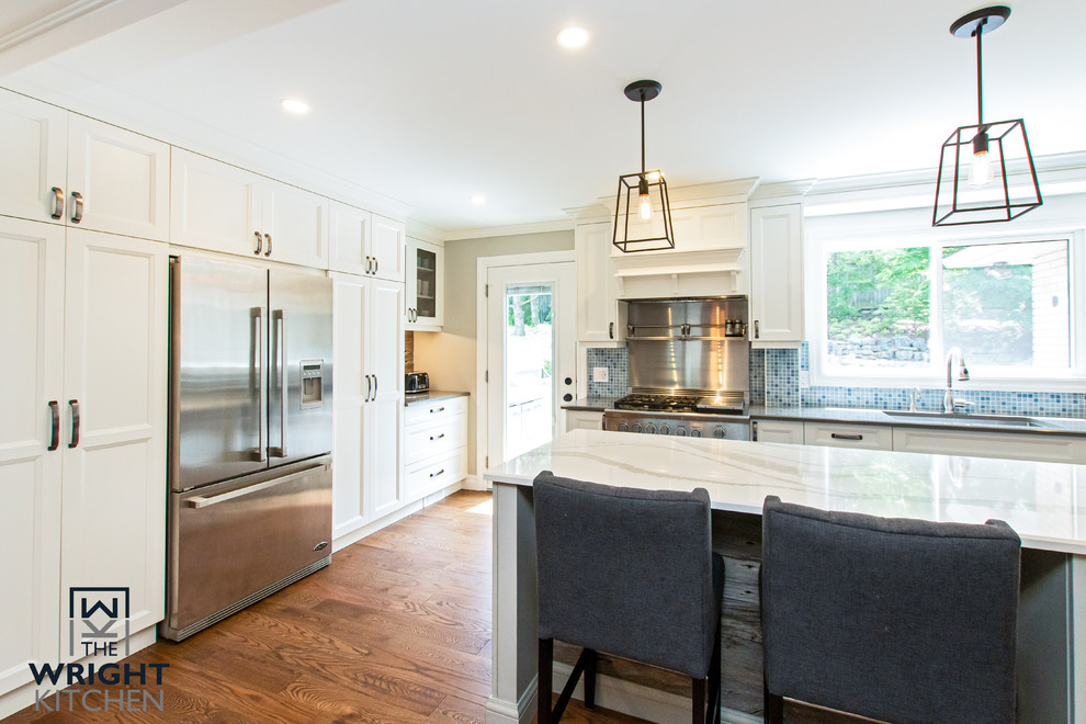 Kitchen - large transitional medium tone wood floor and brown floor kitchen idea in Toronto with an undermount sink, shaker cabinets, white cabinets, wood countertops, blue backsplash, mosaic tile backsplash, stainless steel appliances and white countertops