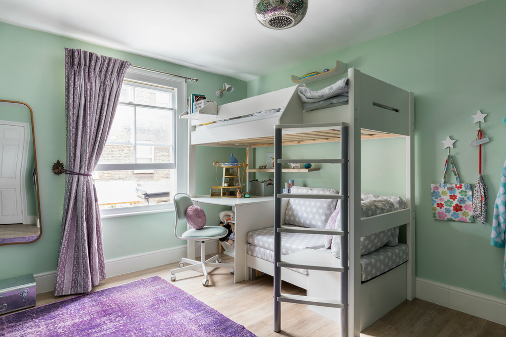 Design ideas for a mid-sized country kids' bedroom for kids 4-10 years old and girls in London with light hardwood floors, green walls and beige floor.