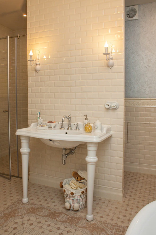 Photo of a traditional bathroom in Other with beige tile, subway tile and a console sink.