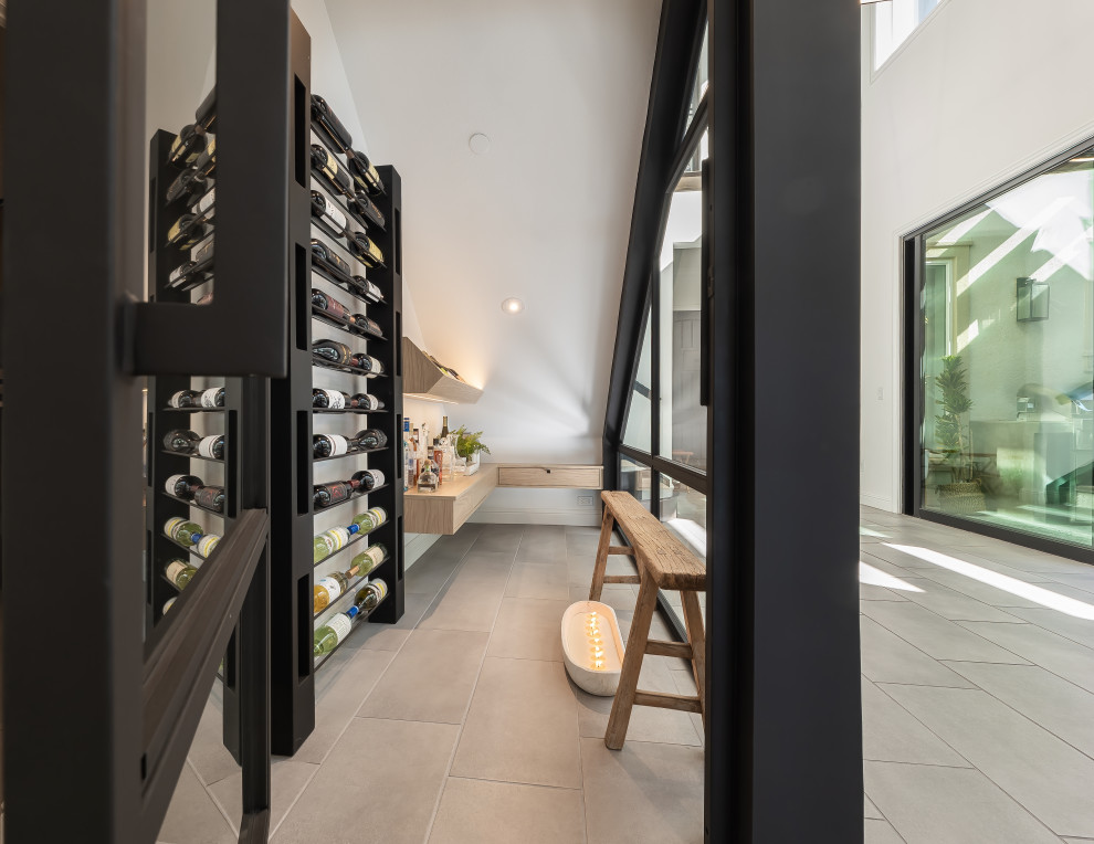 Photo of a small contemporary wine cellar in Los Angeles with porcelain flooring, display racks and grey floors.
