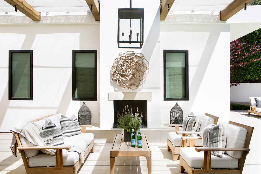 Trendy backyard concrete patio photo in Orange County with a pergola and a fireplace