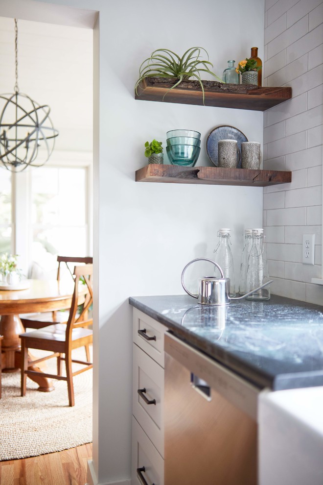 Rockville - Inspiration for a large country l-shaped medium tone wood floor and brown floor enclosed kitchen remodel in Richmond with a farmhouse sink, white cabinets, wood countertops, white backsplash, subway tile backsplash, stainless steel appliances, an island, brown countertops and shaker cabinets