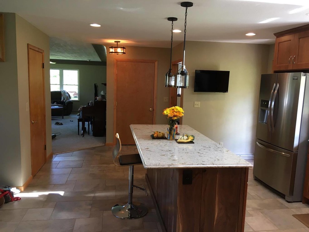 Example of a mid-sized transitional l-shaped porcelain tile and multicolored floor eat-in kitchen design with an undermount sink, recessed-panel cabinets, medium tone wood cabinets, quartz countertops, beige backsplash, porcelain backsplash, stainless steel appliances and an island