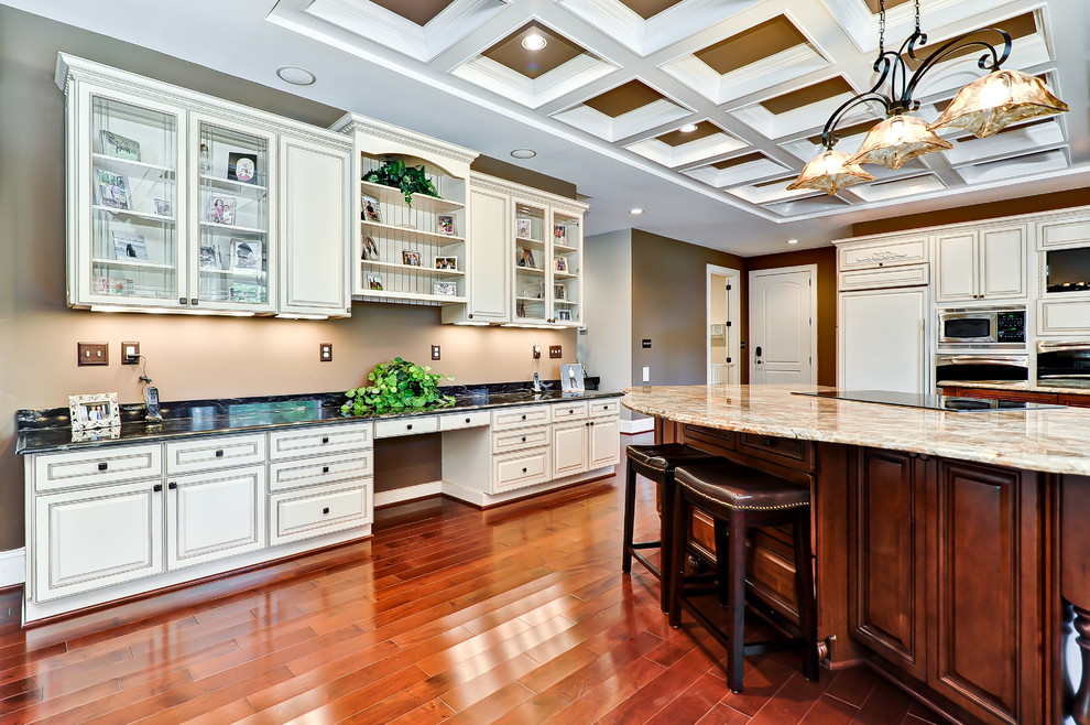 Design ideas for a traditional u-shaped eat-in kitchen with an undermount sink, raised-panel cabinets and white cabinets.