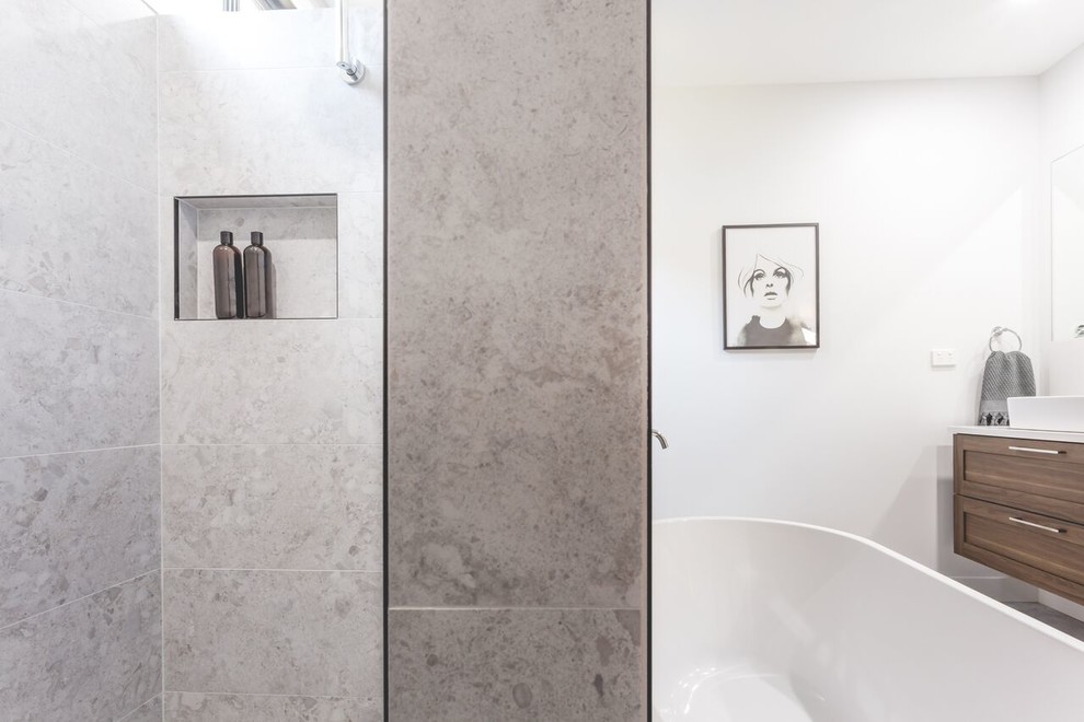 Inspiration for a large contemporary master gray tile and mosaic tile terrazzo floor and white floor bathroom remodel in Newcastle - Maitland with recessed-panel cabinets, medium tone wood cabinets, a two-piece toilet, gray walls, a wall-mount sink and quartz countertops
