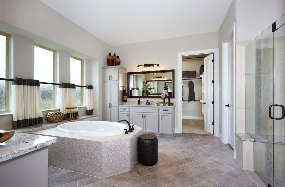 Design ideas for a large country master bathroom in Austin with raised-panel cabinets, beige cabinets, an undermount tub, an alcove shower, black tile, ceramic tile, beige walls, ceramic floors, an undermount sink, granite benchtops, beige floor and a hinged shower door.