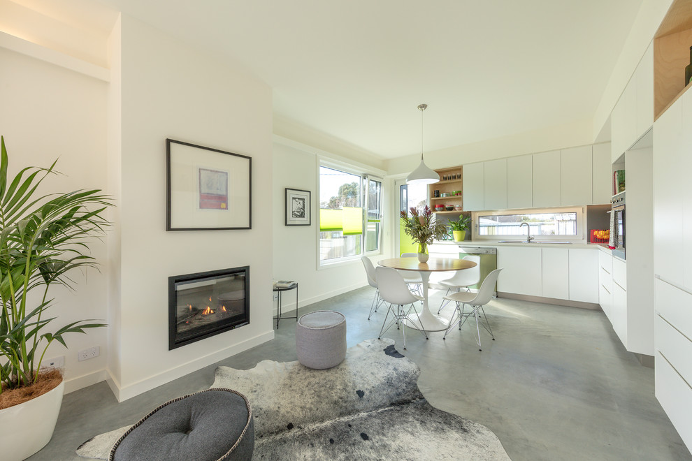 This is an example of a small contemporary open plan dining in Canberra - Queanbeyan with concrete floors and grey floor.