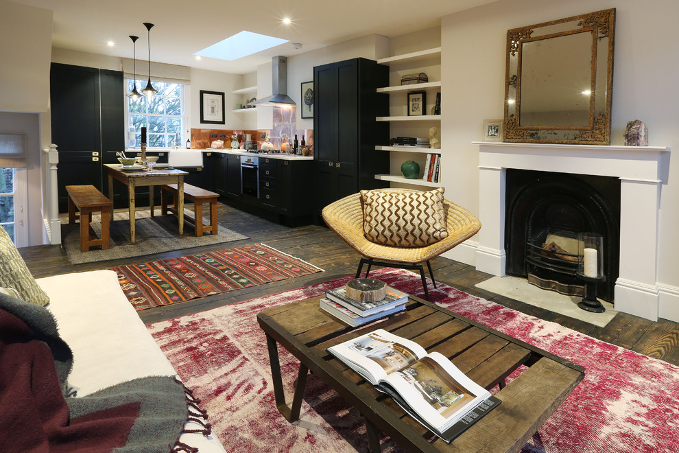 Inspiration for a mid-sized eclectic open concept living room in London with white walls, medium hardwood floors, a standard fireplace, a stone fireplace surround and no tv.