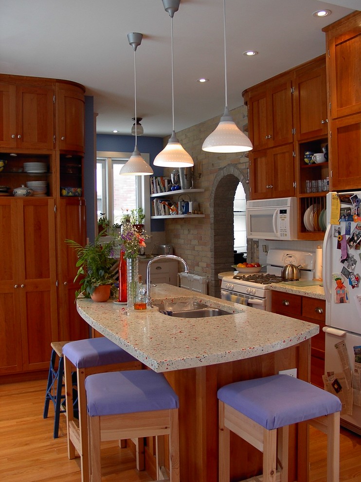 Example of a transitional medium tone wood floor kitchen design in Toronto with an undermount sink, shaker cabinets, medium tone wood cabinets, quartzite countertops, white backsplash, white appliances and an island