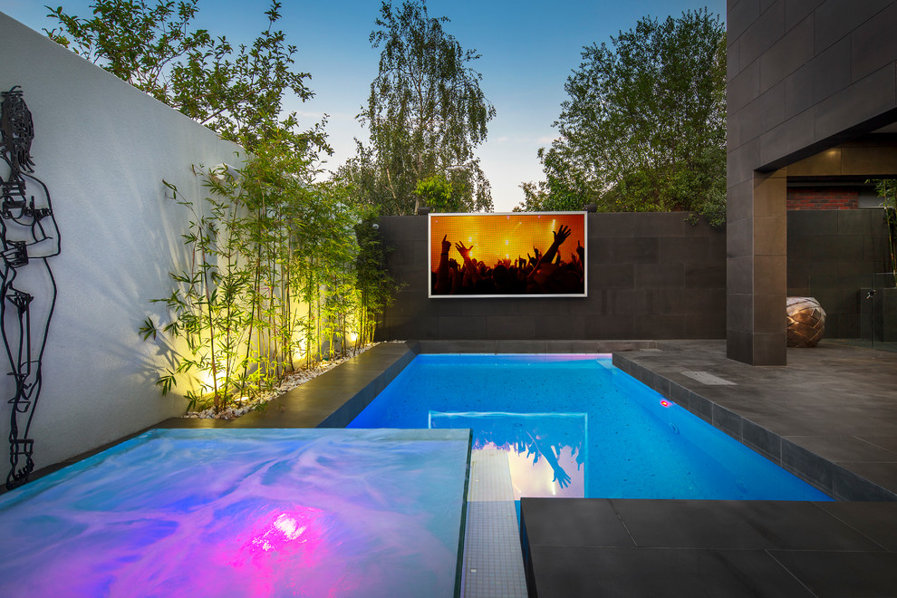 Mid-sized contemporary backyard rectangular lap pool in Melbourne with a hot tub and concrete pavers.