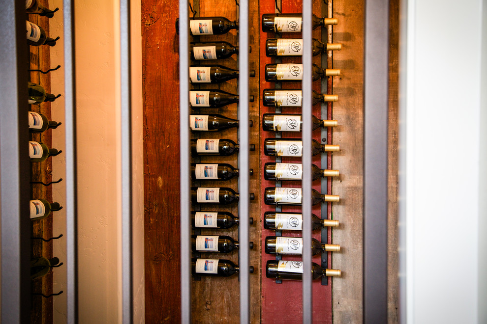 This is an example of a small transitional wine cellar in Boston with medium hardwood floors and storage racks.