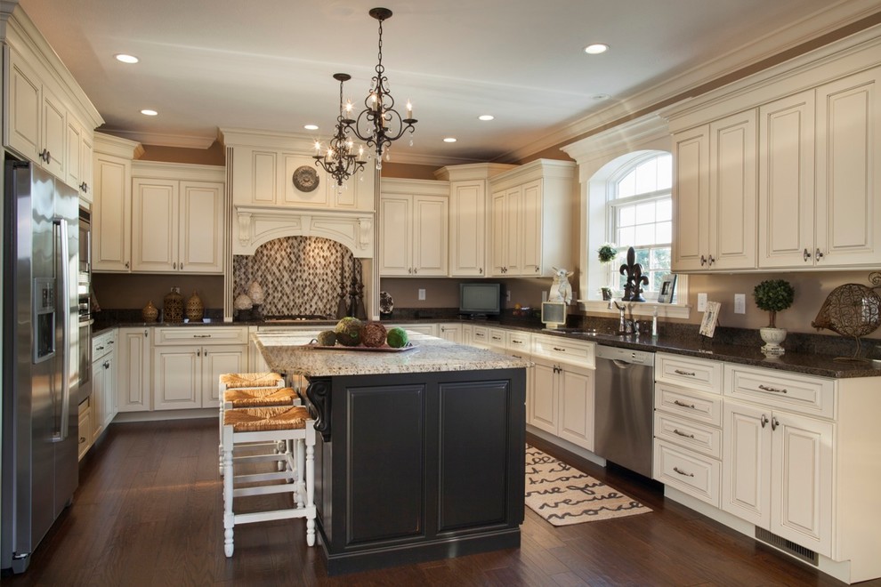 Inspiration for a mid-sized traditional l-shaped eat-in kitchen in Cincinnati with a drop-in sink, glass-front cabinets, medium wood cabinets, stainless steel appliances, medium hardwood floors and with island.