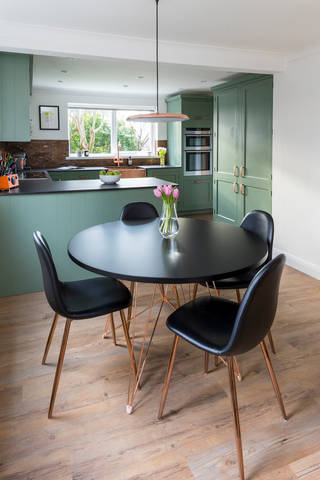 Design ideas for a mid-sized traditional u-shaped eat-in kitchen in Kent with a farmhouse sink, shaker cabinets, green cabinets, quartz benchtops, metal splashback, linoleum floors, a peninsula and green floor.