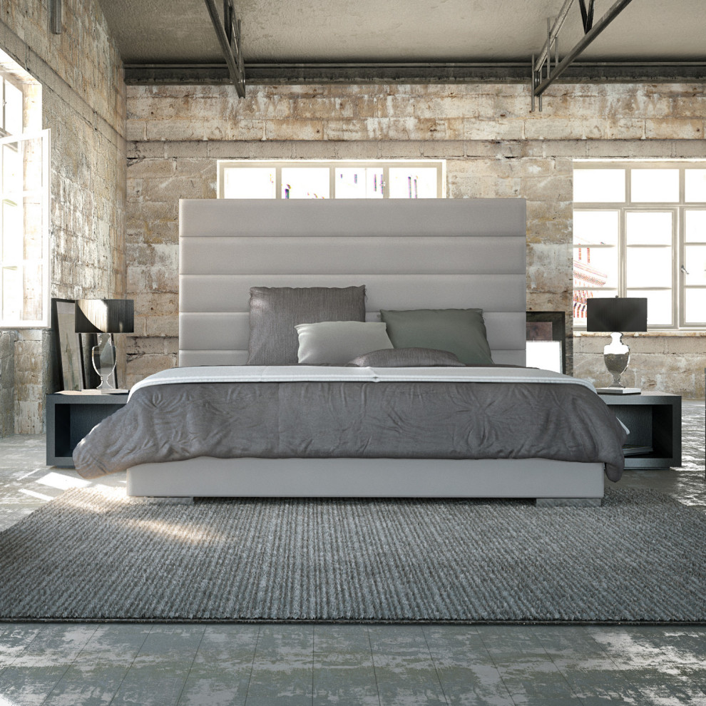 Inspiration for a mid-sized industrial loft-style bedroom in New York with multi-coloured walls, light hardwood floors and grey floor.
