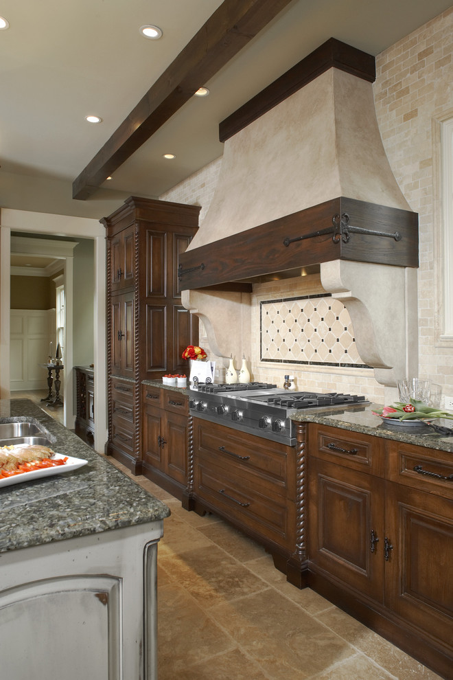 Design ideas for a country kitchen in Atlanta with stainless steel appliances, raised-panel cabinets, granite benchtops, beige splashback, medium wood cabinets and travertine splashback.