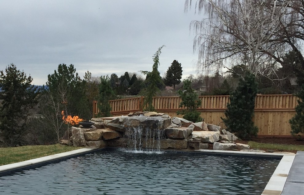 Photo of a large arts and crafts backyard rectangular lap pool in Boise with a water feature and concrete slab.