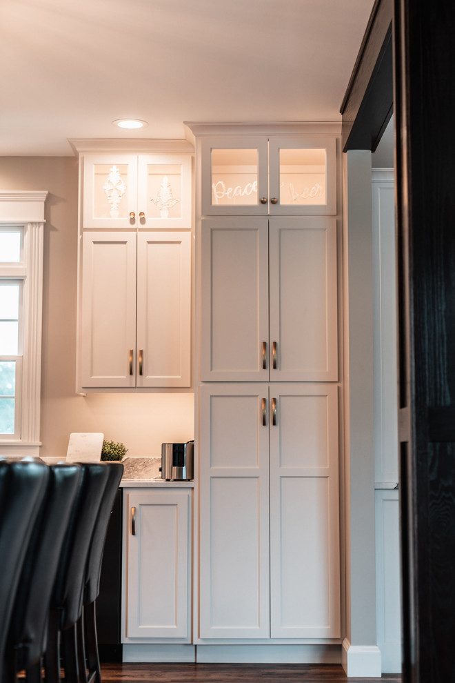 Open concept kitchen - large transitional l-shaped medium tone wood floor and brown floor open concept kitchen idea with an undermount sink, flat-panel cabinets, white cabinets, quartz countertops, multicolored backsplash, quartz backsplash, black appliances, an island and multicolored countertops