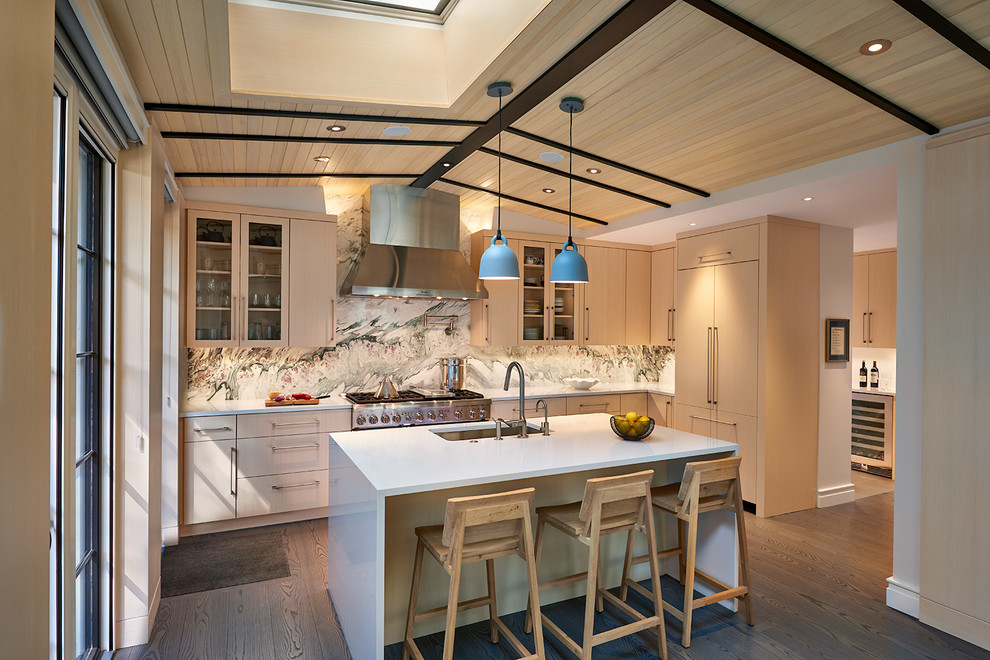 This is an example of a contemporary kitchen in DC Metro with an undermount sink, glass-front cabinets, light wood cabinets, multi-coloured splashback, stone slab splashback, stainless steel appliances, with island and dark hardwood floors.